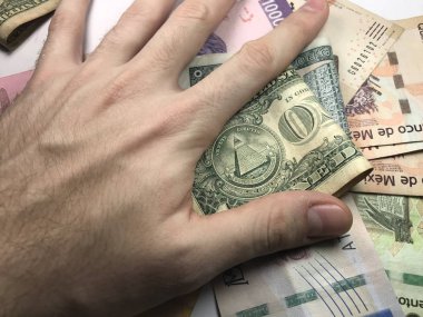 Meksika pezosu faturaları üzerlerinde bir el ile düz bir yüzeye rasgele yayıldı