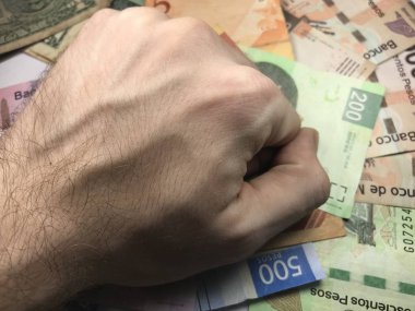 Meksika pezosu faturaları üzerlerinde bir el ile düz bir yüzeye rasgele yayıldı