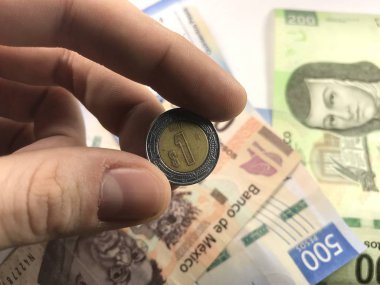 Meksika pezosu faturaları üzerlerinde bir el ile düz bir yüzeye rasgele yayıldı