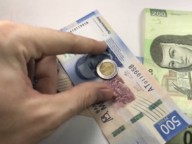 Meksika pezosu faturaları üzerlerinde bir el ile düz bir yüzeye rasgele yayıldı