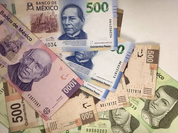 Billetes de pesos mexicanos distribuidos aleatoriamente sobre una superficie plana — Foto de Stock