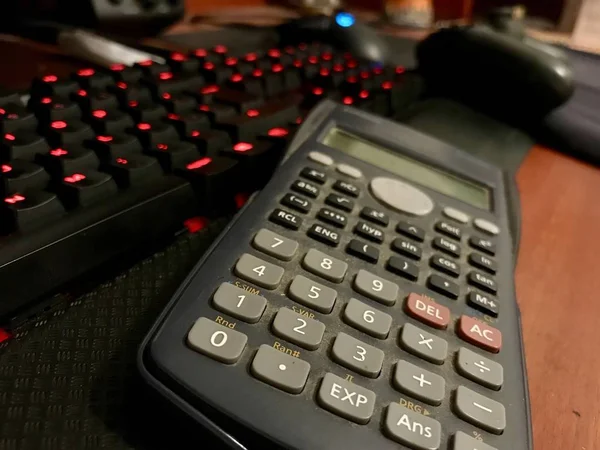 Vetenskaplig kalkylator över ett datortangentbord på en trä-Desk — Stockfoto