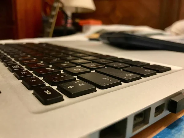 Uitzicht op een zilver metallic laptop computer over een teken notebook op het bed — Stockfoto