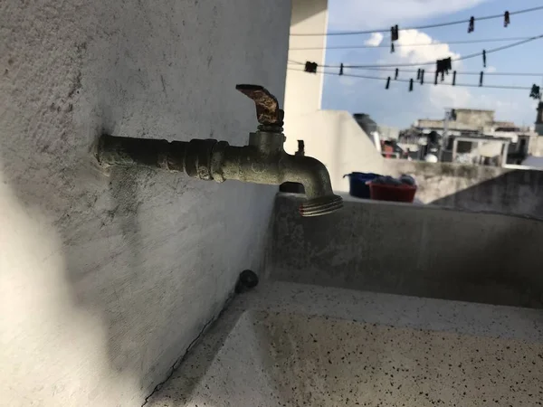 Torneira de água fechada e enferrujada em uma parede branca — Fotografia de Stock