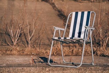 Okyanus tarafında kırmızı sandalye fırtınalı siyah ve beyaz arka plan kontrastlı kayalar.