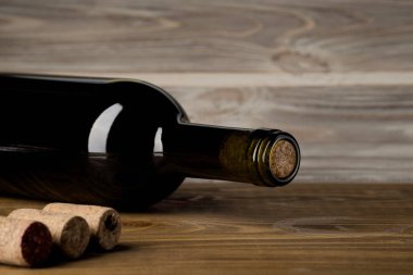 Ahşap arka planda tirbuşonlu bir şişe şarap.