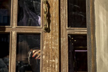 Süpürge'nın el kırmızı çivi ile kapı camın arkasından görünür
