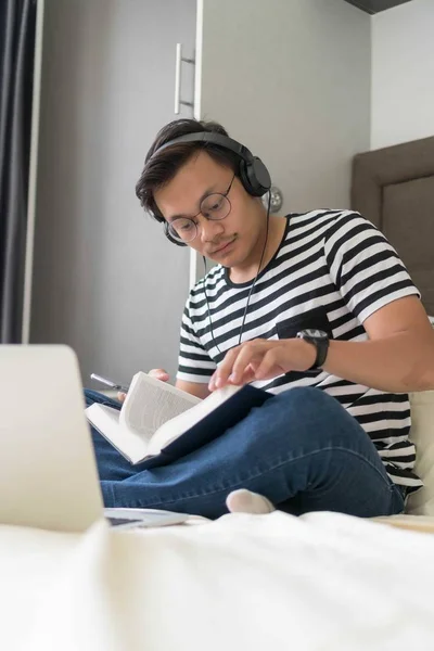 Relaxed casual man reading book on the bed at home