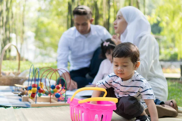 Malay family at recreational park having fun focusing on the little boy
