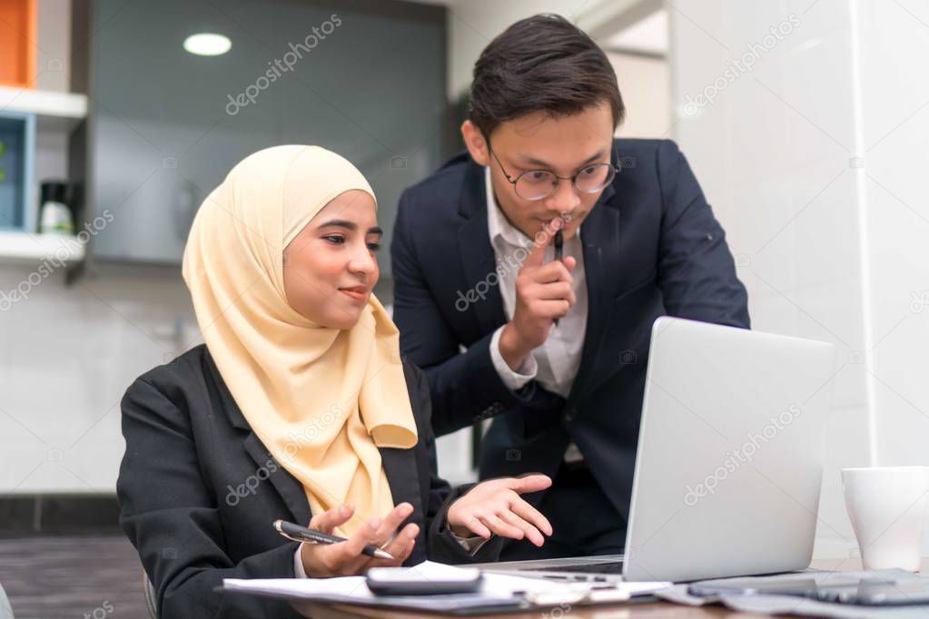 Asian malay executive working at home with laptop discussing