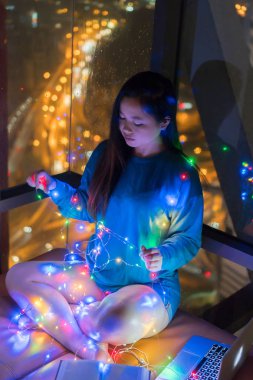 Güzel genç Asyalı kız renkli led lamba ile oynamak