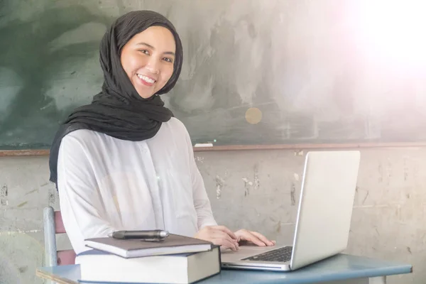 Malay Executive wearing hijab working with laptop