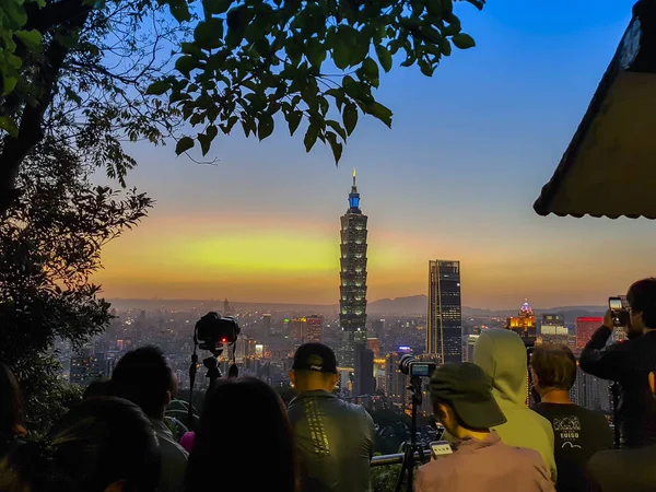 Turista tomando fotos del edificio Taipei 101 durante el atardecer — Foto de Stock