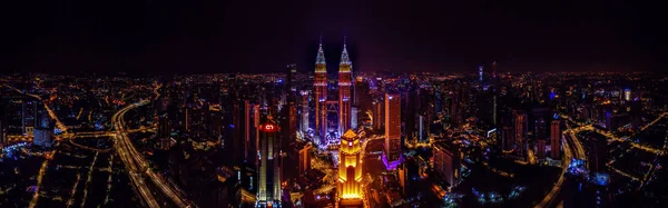 Vista aérea panorámica de los rascacielos en Kuala Lumpur cuando la Torre Petronas se iluminó con los colores de la bandera de Malasia — Foto de Stock