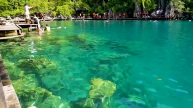 CORON, PHILIPPINE, 11 ARALIK 2019: Turist manzaralı dağ ve küçük göl manzaralı Kayangan Gölü 'nde kristal berrak suyun tadını çıkarıyor