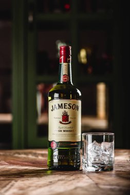 Jameson viski şişe ve cam buz küpleri koyu bar ahşap tablo ile. Jameson Dublin geleneksel İrlanda viski bir markasıdır.