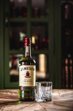 Jameson viski şişe ve cam buz küpleri koyu bar ahşap tablo ile. Jameson Dublin geleneksel İrlanda viski bir markasıdır.