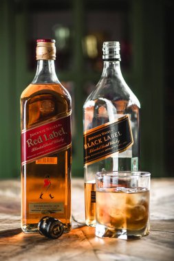Kırmızı etiket ve Black label viski şişeleri ve cam ahşap masa buz küpleri ile. Johnnie Walker harmanlanmıştır Scotch viski dünyada ünlü markalardan biri ise