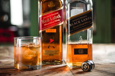 Kırmızı etiket ve Black label viski şişeleri ve cam ahşap masa buz küpleri ile. Johnnie Walker harmanlanmıştır Scotch viski dünyada ünlü markalardan biri ise