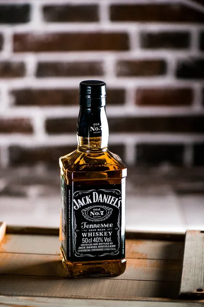 Jack Daniels viski şişesi üzerinde tahta bir kutu. Arka plan üzerinde tuğla duvar. Jack Daniels en çok satan Amerikan viski dünya ve ünlü viski markası olduğunu