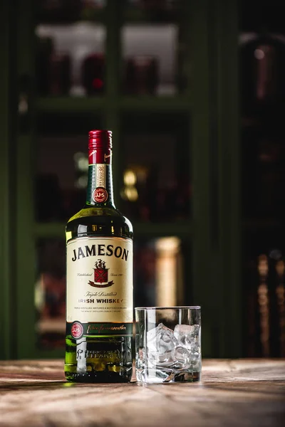 Jameson viski şişe ve cam buz küpleri koyu bar ahşap tablo ile. Jameson Dublin geleneksel İrlanda viski bir markasıdır.