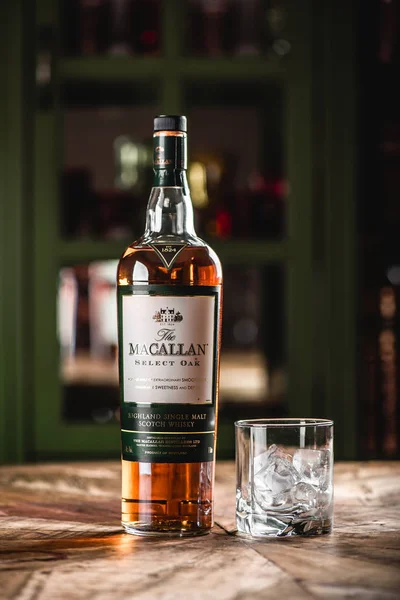 Macallan viski şişe ve cam ile buz küpleri ahşap masa üzerinde çubuk. Macallan elite kategori tek malt İskoç viski parlak bir temsilcisidir