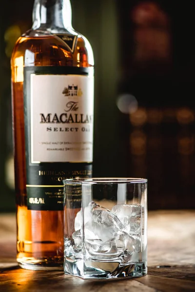 Macallan viski şişe ve cam ile buz küpleri ahşap masa üzerinde çubuk. Macallan elite kategori tek malt İskoç viski parlak bir temsilcisidir