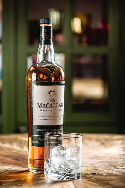 Macallan viski şişe ve cam ile buz küpleri ahşap masa üzerinde çubuk. Macallan elite kategori tek malt İskoç viski parlak bir temsilcisidir