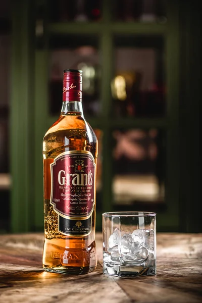 Grant'ın viski şişe ve cam buz küpleri koyu bar ahşap tablo ile. Hibe olduğunu harmanlanmıştır Scotch viski ve bir en dinamik olarak dünya markaları geliştirme
