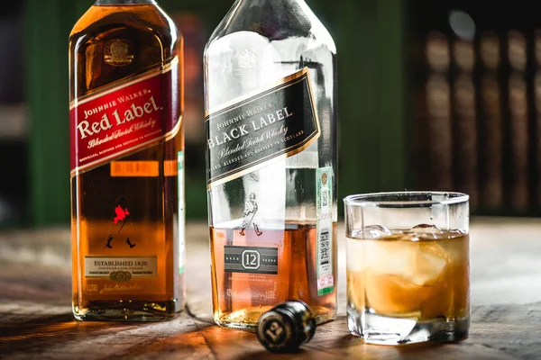 Kırmızı etiket ve Black label viski şişeleri ve cam ahşap masa buz küpleri ile. Johnnie Walker harmanlanmıştır Scotch viski dünyada ünlü markalardan biri ise