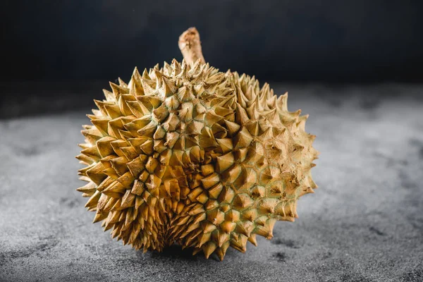 Beton masada Durian egzotik meyve Asya'dan. Karanlık anahtar
