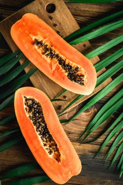 Papaya Asya egzotik meyve. Yarı tropik meyve bıçağı ve tablo kaşık ile. Turuncu hamuru siyah tohumları