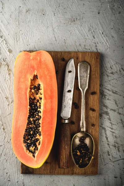Papaya Asya egzotik meyve. Yarı tropik meyve bıçağı ve tablo kaşık ile. Turuncu hamuru siyah tohumları
