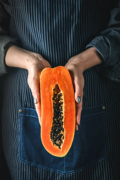 Papaya Asya egzotik meyve. Yarı tropik meyve kadınların elinde. Turuncu hamuru siyah tohumları
