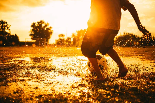 Güneşin altında topluluk kırsal alanda egzersiz için futbol futbol oynayan çocuklar bir grup bir eylem spor resmi.
