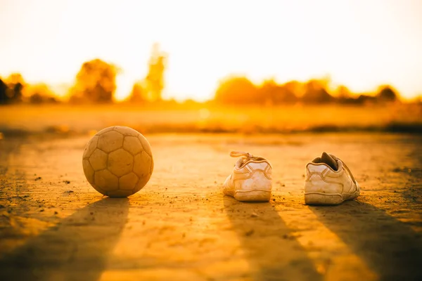 Street soccer football and shoes in the field