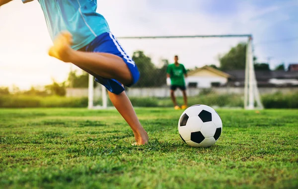 Yeşil çim alanında egzersiz için futbol oynayan bir grup çocuk bir aksiyon spor resmi.