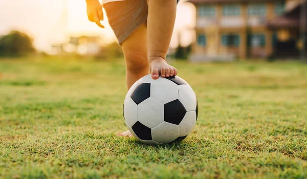 Yeşil çim alanında egzersiz için futbol oynayan bir grup çocuk bir aksiyon spor resmi.