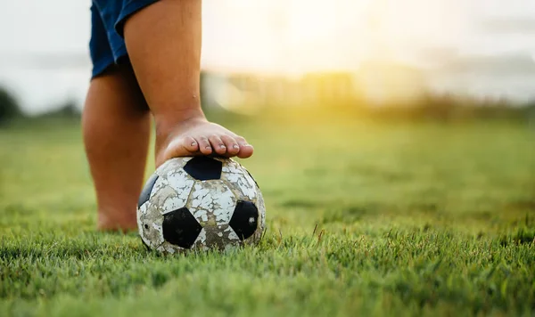 An action sport picture of a group of kids playing soccer football for exercise in the green grass field.