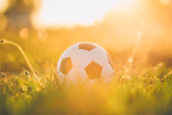 Gün batımı ışını ışığı altında sokak futbolu futbol için bir top. Film resmi tarzı.