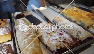 Bir restoran pencerede bir fırın tepsisine pudra şekeri ve cheesecakes yalanla strudels serpilir