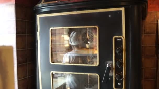 Reflejo del chef pastelero en el vaso del horno — Vídeo de stock