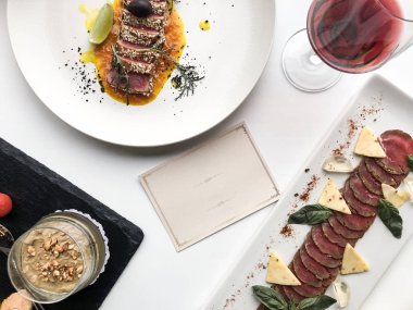 Kart veya kartpostal, kırmızı şarap, servis restoran masası için boş desen ile peynir ile dilimlenmiş ton balığı ve prosciutto