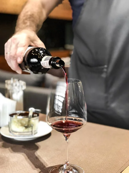 Barmen (barmen) bir cam içine kırmızı şarap dökülen, şarap dergisi için iyi bir fotoğraf 