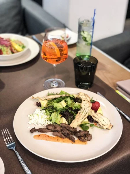 Dana ve çiftlik peyniri ile baharatlı salata/salata ve limonata ile restoran masası servis/akşam yemeği için taze içecekler/yemek kitabı, alış defteri veya gıda dergisi için mükemmel yüksek çözünürlüklü resim