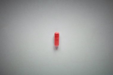 Sade bir arkaplanda bir kırmızı hap