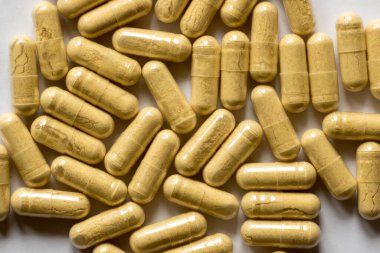 Masaya saçılmış sarı haplar