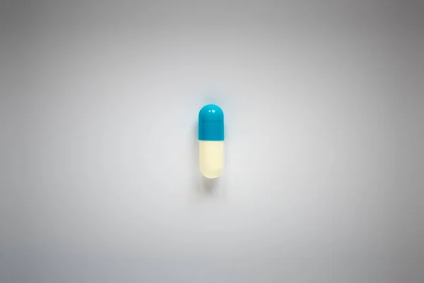 Una Píldora Azul Blanca Sobre Fondo Liso — Foto de Stock