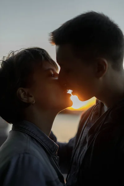 Close up portrait of a lovely young couple smiling before kissing against sunset — Stock Photo, Image