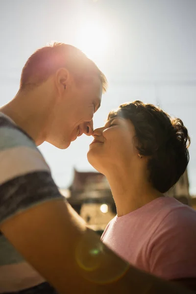 Nahaufnahme Porträt eines schönen jungen Paares, das lächelt, bevor es sich gegen Sonnenuntergang küsst — Stockfoto